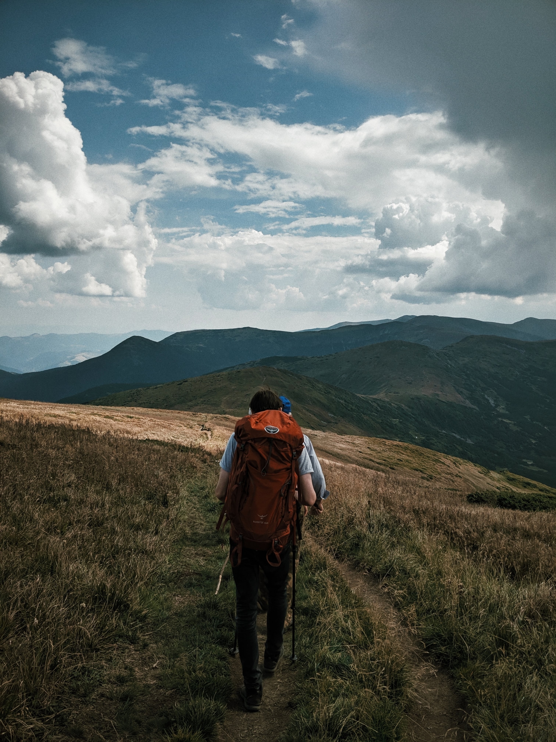 Ein Wanderer wandert auf einem grasbewachsenen Berg