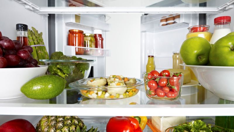 Lebensmittel (div. Obst und Gemüse, Einmachgläser) in einen gut sortierten Kühlschrank
