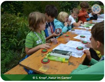 Kinder am Tisch beim Experimentieren