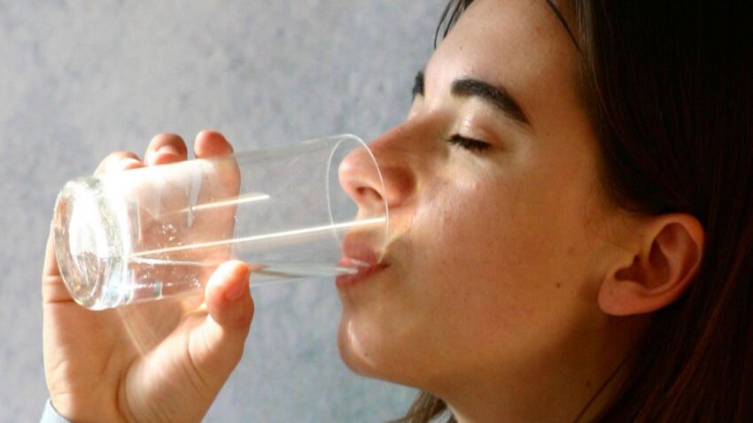 Eine Frau die ein Glas Wasser trinkt