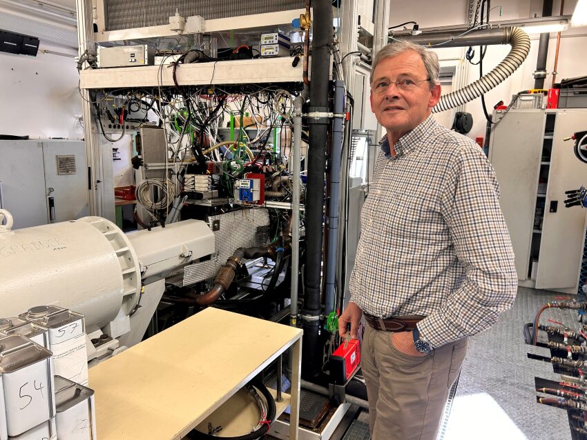 Univ.Prof. Dr. Helmut Eichlseder steht vor einer Maschine die mit E-Mobilität funktioniert