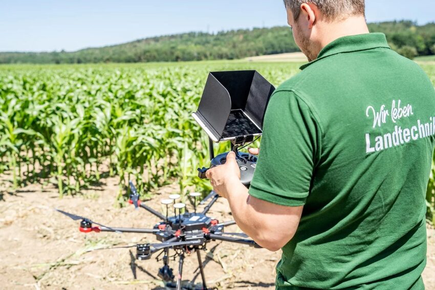 Ein Mann der eine Drohne über ein Feld fliegen lassen wird