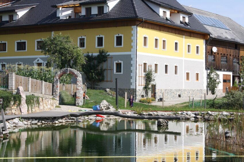 Ein großer Hof mit einem Garten und großen Teich davor