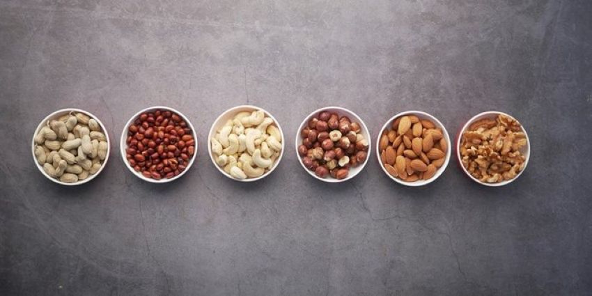 6 bowls filled with beans and different types of nuts.