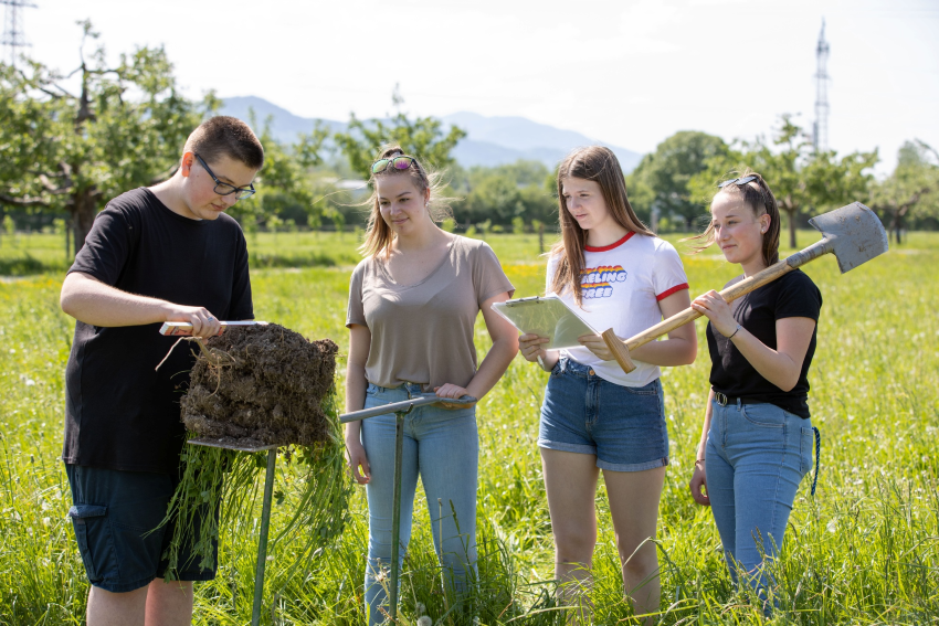 Schüler und Schülerinnen der LFS Kleßheim draußen beim untersuchen eines Stück Bodens