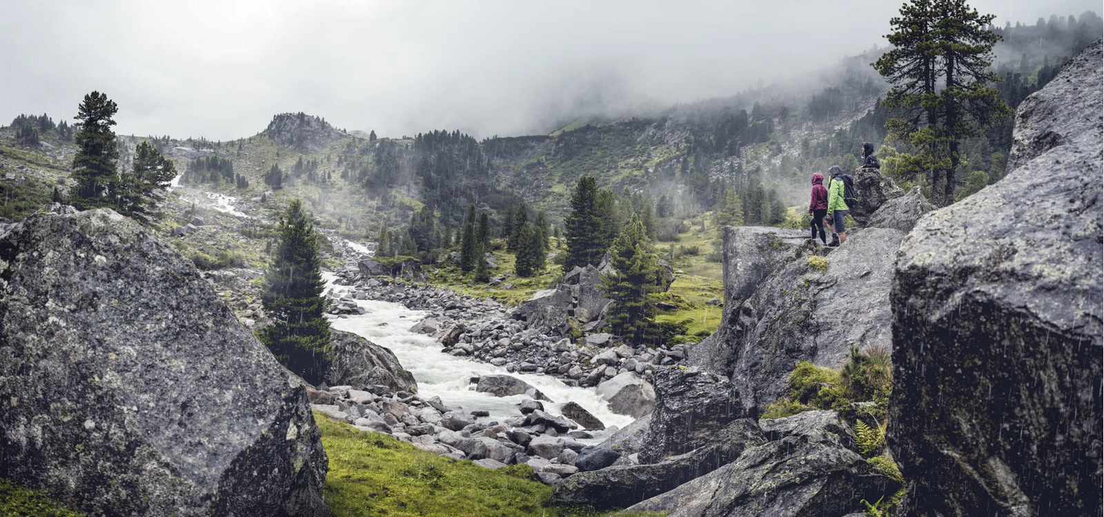 Blick von einem Felsvorsprung auf einen Fluss und Geröll der Hohen Tauern