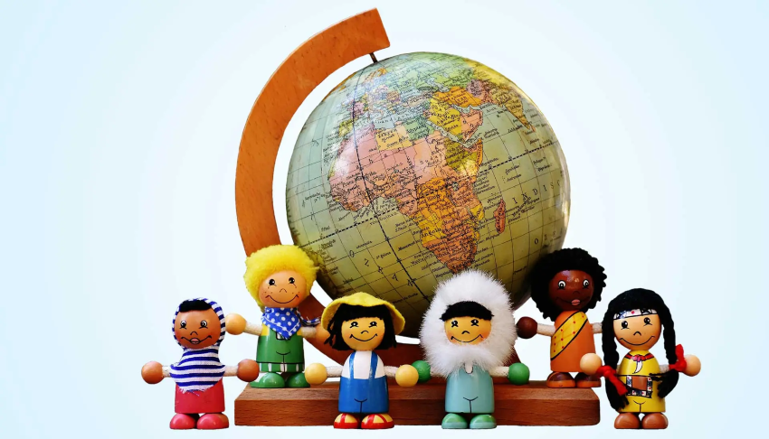 Ein Globus und Puppenkinder verschiedener Herkunft stehen davor
